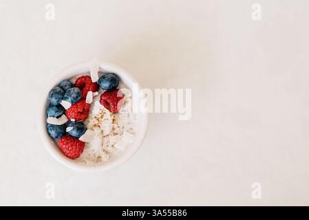 Eine minimalistische Schüssel Kokosjoghurt mit Beeren und Zimt Stockfoto