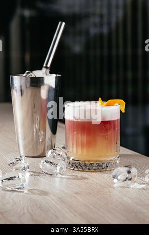 Saurer Cocktail mit Eis und Orangenschale Stockfoto
