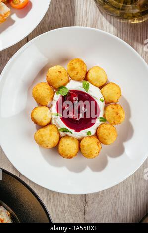 Käsekuchen mit Sauerrahm und Beerensauce Stockfoto