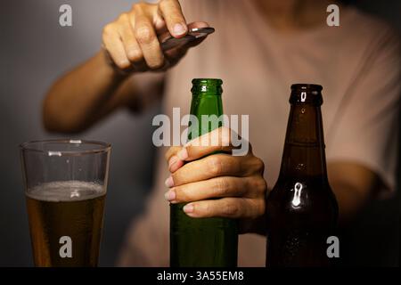 Hands Opening Beer Bottle on the Room, Hintergrund für Werbung und Tapeten in der Food- und Kulturszene Stockfoto