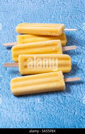 Gelbes Eis auf blauem Hintergrund Stockfoto