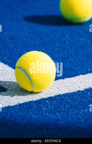 Zwei gelbe Padelbällchen auf blauer Oberfläche eines Paddletennis-Platzes Stockfoto