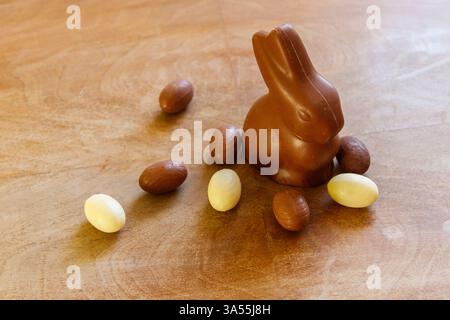 Osterhase und Schokoladeneier auf hölzernem Hintergrund Stockfoto