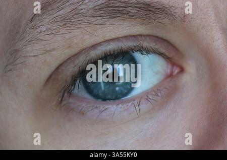 Nahaufnahme des blauen Auges eines Mannes Stockfoto