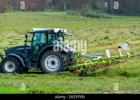 Traktor mit Zedder auf dem Feld Stockfoto
