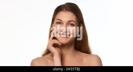 Schöne und selbstbewusste junge Frau mit makellosem Teint, weichem natürlichem Make-up, sanft berührendem Gesicht mit zarten Fingern. Stockfoto