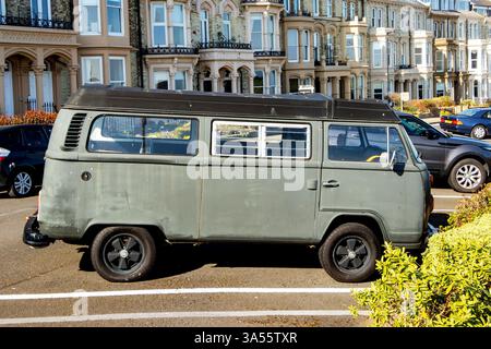 Vintage-grüner volkswagen T2 VW-Bus-Wohnmobil parkt auf percy Terrasse tynemouth mit Reihenterrasse klassische viktorianische Stadthäuser unter klarem blauen Himmel Stockfoto