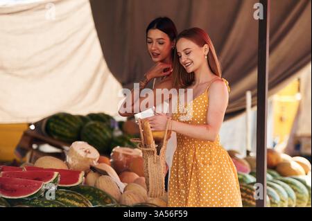 Lächelnd, stehend. Zwei Frauen sind zusammen auf dem Marker oder Basar. Stockfoto