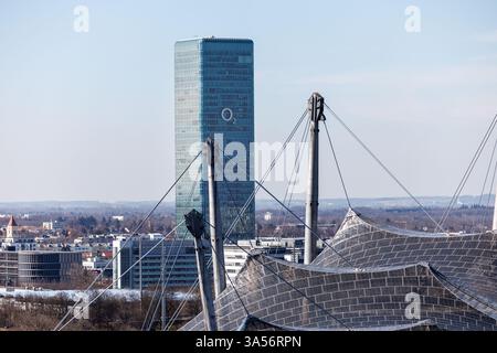 München, Deutschland. März 2025. Der O2 Tower in München (Bayern). Die Olympiaanlage im Olympiapark mit dem Olympiastadion ist im Vordergrund zu sehen. O2 ist die Marke des Telekommunikationsunternehmens Telefonica. Mit dem O2-Netz (Telefonica-Netz) betreibt Telefonica das billigste Mobilfunknetz Deutschlands Credit: Matthias Balk/dpa/Alamy Live News Stockfoto