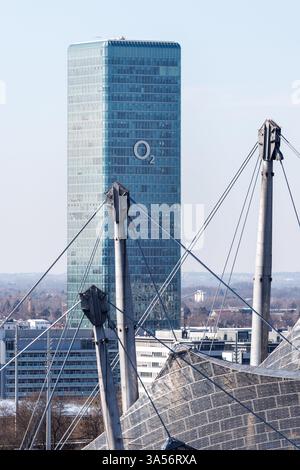 München, Deutschland. März 2025. Der O2 Tower in München (Bayern). Die Olympiaanlage im Olympiapark mit dem Olympiastadion ist im Vordergrund zu sehen. O2 ist die Marke des Telekommunikationsunternehmens Telefonica. Mit dem O2-Netz (Telefonica-Netz) betreibt Telefonica das billigste Mobilfunknetz Deutschlands Credit: Matthias Balk/dpa/Alamy Live News Stockfoto