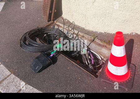 Wartungs- oder Installationsarbeiten an vergrabenen Glasfaserkabeln und -Leitungen für das Internet in einer Stadtstraße Stockfoto