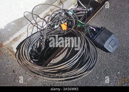 Wartungs- oder Installationsarbeiten an vergrabenen Glasfaserkabeln und -Leitungen für das Internet in einer Stadtstraße Stockfoto