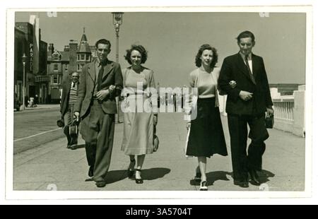 Originales, typisches Schnappschussfoto aus der Zeit nach dem 2. Weltkrieg aus den 1940er Jahren von den Fotografen Walfred of Skegness am Meer von zwei spazierenden Paaren im Urlaub, elegant gekleidet, die einen entspannenden Spaziergang entlang der Grand Parade genießen - gute Mode-/Friseurdetails. Hübsche Damen. Auf der Rückseite datiert 1949. Skegness, Lincolnshire, England, Großbritannien Stockfoto