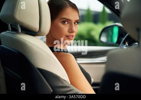 Rückblickend. Die Frau sitzt im Auto. Stockfoto
