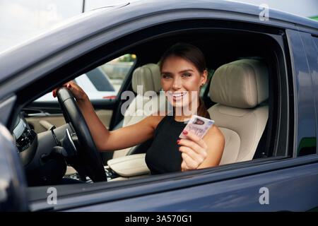 Die Frau sitzt im Auto. Stockfoto