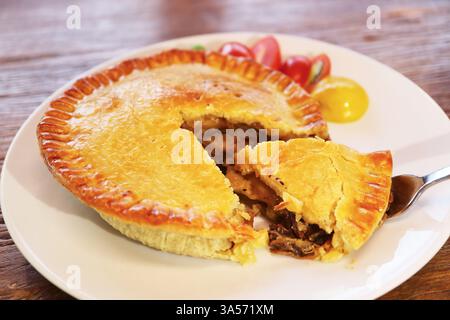 Köstlicher Golden Brown Beef Pie, serviert auf Holztisch Stockfoto