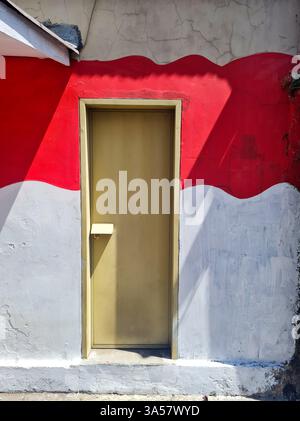Ein Haus in Indonesien, das rot-weiß im Stil der indonesischen Nationalflagge bemalt ist. Stockfoto