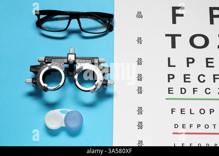 Brille, Testrahmen, Vision-Testkarte und Linsen auf hellblauem Hintergrund, flach gelegt Stockfoto