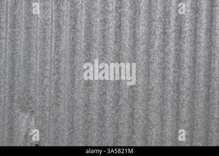 Ein Blech mit einem Muster aus Linien und Punkten. Das Image hat ein stimmungsvolles und industrielles Gefühl Stockfoto