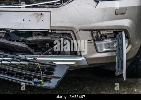 Beschädigtes silbernes Auto auf dem Parkplatz mit Frontalkollision Stockfoto