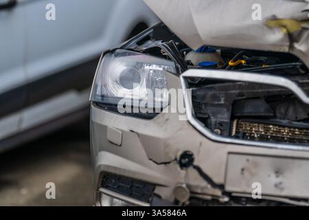 Beschädigtes silbernes Auto auf dem Parkplatz mit Frontalkollision Stockfoto