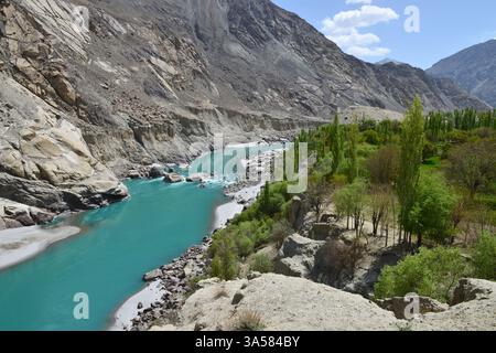 Ein Luftpanorama eines Tals und eines fließenden Flusses aus grünem Gletscherwasser, zwischen den umliegenden Bergen. Stockfoto