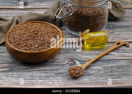 Leinsamen. Leinsamenpulver in einem Holzlöffel. Steht auf einem Holzhintergrund. Stockfoto