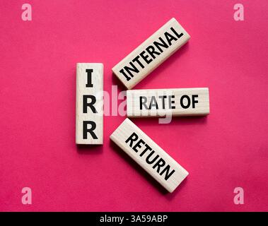 IRR - Internal Rate of Return symbol. Concept word IRR on wooden cubes. Beautiful red background. Business and IRR concept. Copy space. Stockfoto