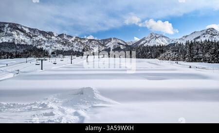 Großer Panoramablick auf schneebedeckte Berge, Bäume und Sessellift. Maiko, Niigata Stockfoto