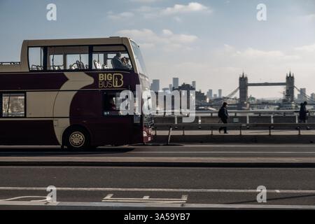 London, 14. Februar 2025: Ein Big Bus Hop on - Hop Off Doppeldecker auf der London Bridge, Tower Bridge im Hintergrund. Stockfoto