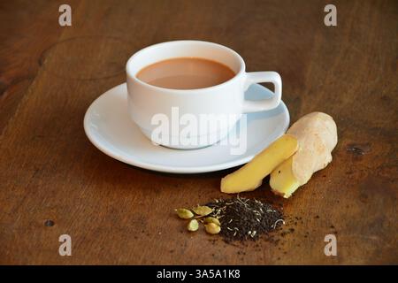 Eine Tasse heißer Kaffee mit Zutatendekoration, auf den braunen Tisch gestellt Stockfoto