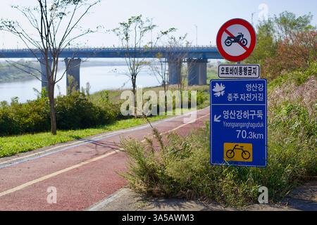 Naju City, Südkorea - 24. September 2020: Ein blaues Radwegsschild entlang des Yeongsangang Bike Path weist auf eine 70,3 km lange Entfernung zum Yeongsangang H hin Stockfoto