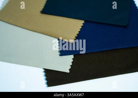 Ein Satz von Stofffeldern in verschiedenen Farben, die auf weißem Hintergrund angezeigt werden. Perfekt für moderne Mode und zeitgenössische Designprojekte. Stockfoto