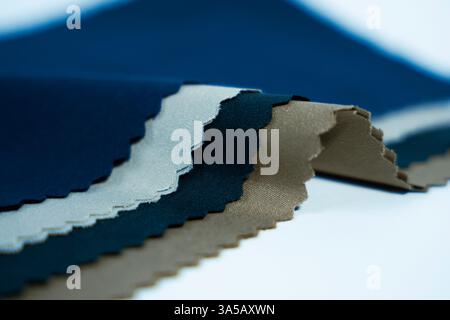 Eine detaillierte Nahaufnahme eines Stoffes aus Leinen, das seine robuste Textur und verschiedene Farben auf weißem Hintergrund zeigt. Perfekt für zwanglose und streetwe Stockfoto