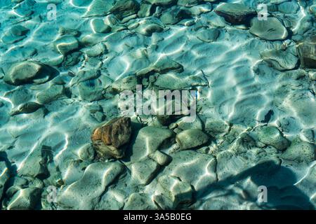 Kristallklares Flachwasser mit Kräuseln und Steinen im tropischen Meer Stockfoto