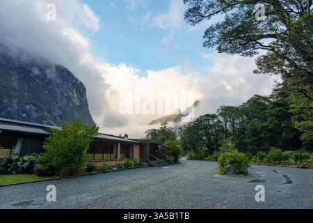 Ruhige Landschaft eines modernen Gebäudes mit nebligen Bergen im Regenwald am Morgen in Neuseeland Stockfoto