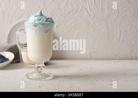 Glas blauer Dalgona Matcha Latte auf Grunge Tisch Stockfoto