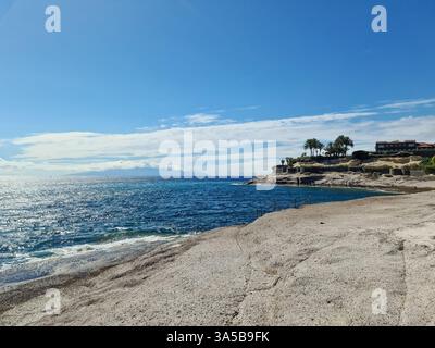 Atemberaubende Meereslandschaft, die die Schönheit von Playa de las Americas mit der am Horizont sichtbaren Insel La Gomera, Teneriffa und den Kanarischen Inseln zeigt Stockfoto
