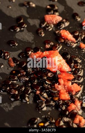Wassermelonenkerne und Zellstoff auf schwarzem Schiefer, Wassermelonenkerne nach dem Schälen auf schwarzem Stein Stockfoto