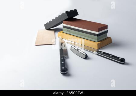 Weißer Hintergrund auf dem Ständer befindet sich die gesamte Ausrüstung ein Set zum Schärfen und Polieren von Küchenmessern und verschiedenen Klingen mit unterschiedlicher Abrasivität von Steinen Stockfoto