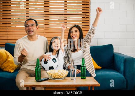 Eine glückliche Familie genießt den Nervenkitzel eines Fußballspiels zu Hause Stockfoto