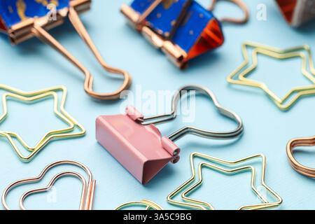 Verschiedene Papier- und Binderklammern auf hellblauem Hintergrund, Nahaufnahme Stockfoto