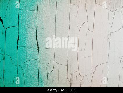 Abstrakter Vintage-Hintergrund mit altem Zaun mit gerissener und abblätternder Farbe in grünen weißen Farben. Fragment der verwitterten rauen Wandkulisse. Stockfoto