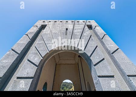 Bewaldete Hügel sind durch den Obelisken auf der Rogue River Bridge am Gold Beach in Oregon, USA, sichtbar Stockfoto