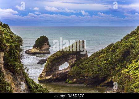 Malerische Küste der Südinsel Neuseelands. Felsen und Bögen in der starken Brandung des Pazifiks. Reise an die Enden der Erde. Der Tiefenbereich Stockfoto