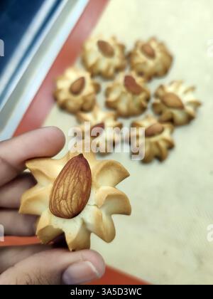 Frisch gebackene Mandelkekse sind wunderschön in einer Bäckerei zubereitet und präsentieren ihre goldene Farbe und nussigen Topping, perfekt für Dessertliebhaber. Stockfoto