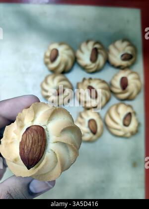 Frisch gebackene Mandelkekse sind wunderschön in einer Bäckerei zubereitet und präsentieren ihre goldene Farbe und nussigen Topping, perfekt für Dessertliebhaber. Stockfoto