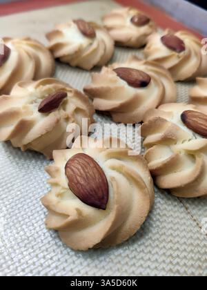 Frisch gebackene Mandelkekse sind wunderschön in einer Bäckerei zubereitet und präsentieren ihre goldene Farbe und nussigen Topping, perfekt für Dessertliebhaber. Stockfoto