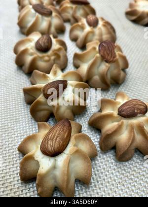 Frisch gebackene Mandelkekse sind wunderschön in einer Bäckerei zubereitet und präsentieren ihre goldene Farbe und nussigen Topping, perfekt für Dessertliebhaber. Stockfoto