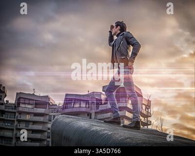 Ein hübscher junger Mann in städtische Einstellung in der modernen Stadt, weit wie ein Explorer, stehen, tragen schwarze Lederjacke und Jeans Stockfoto